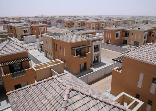 Rooftop view of terracotta-roofed villas under construction in Al Ain