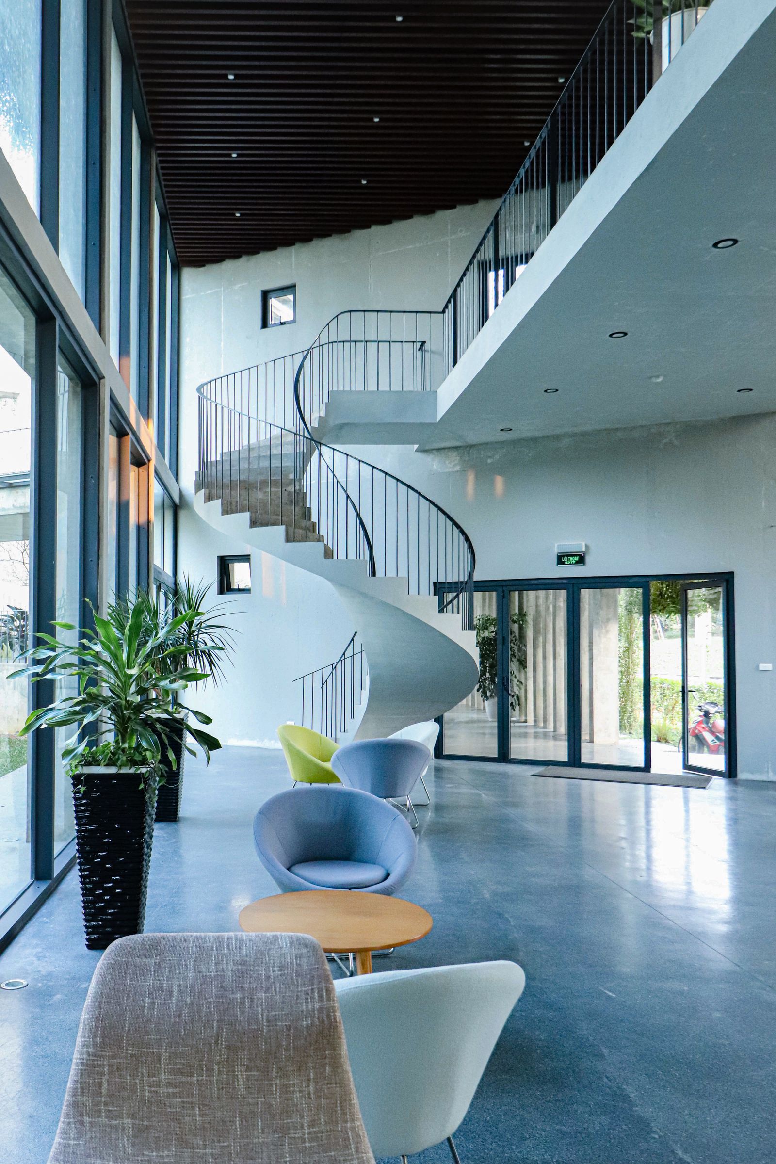 Spacious modern hotel lobby with a curved spiral staircase