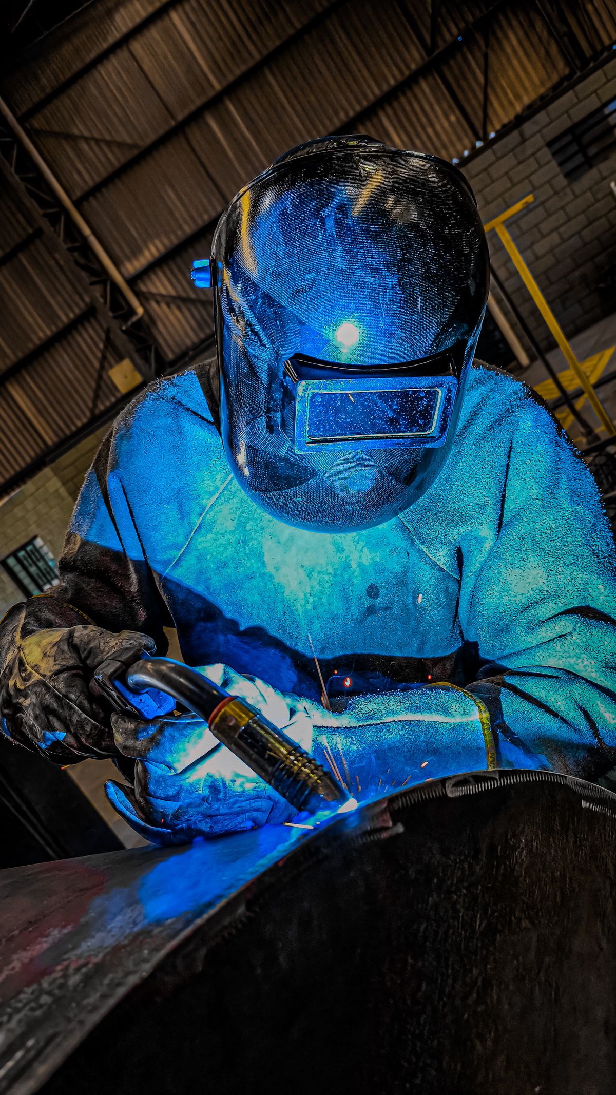Welder working on steel with a protective mask
